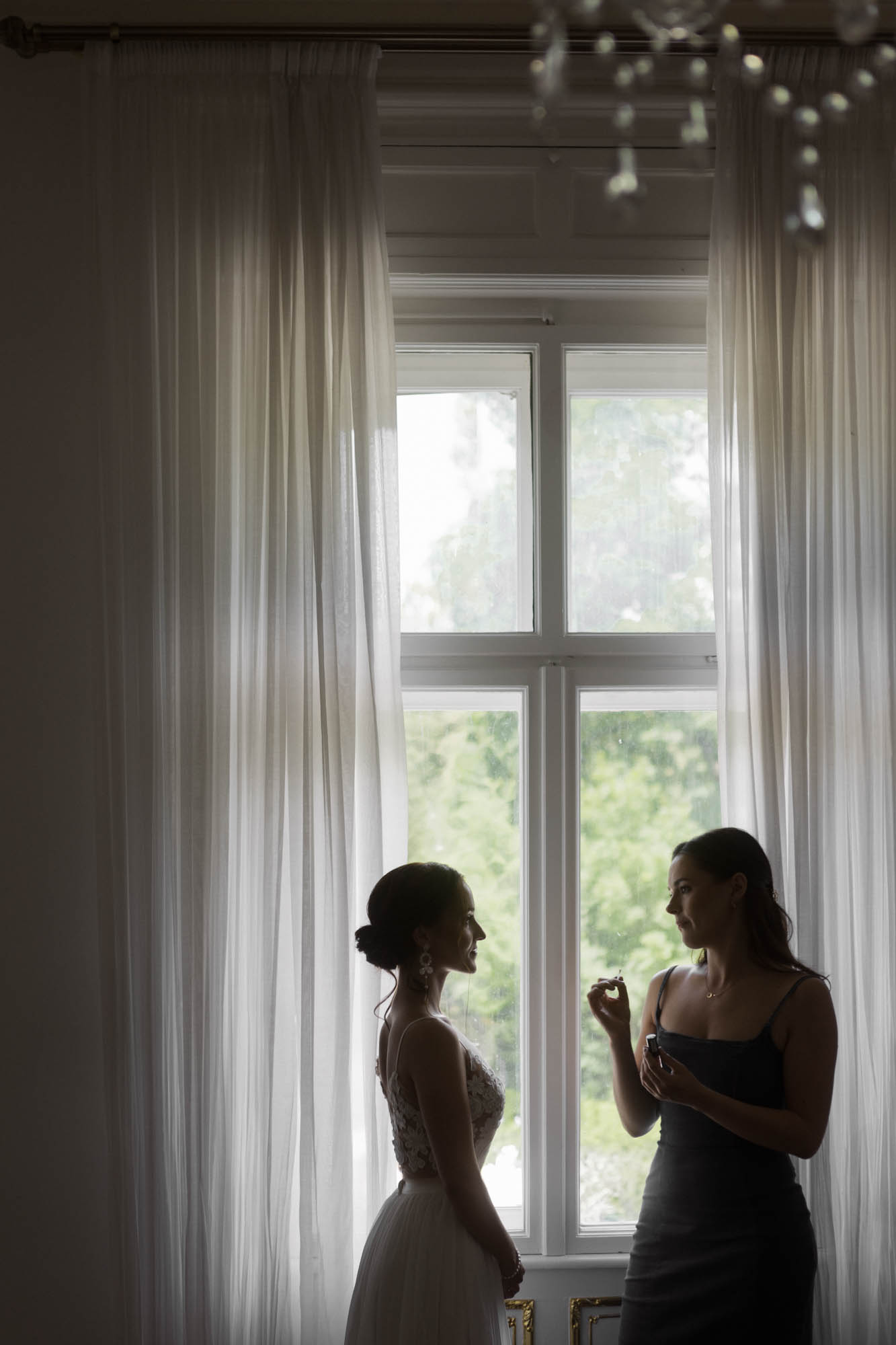 Hochzeitsfotograf München Braut und Brautjungfer vor Fenster